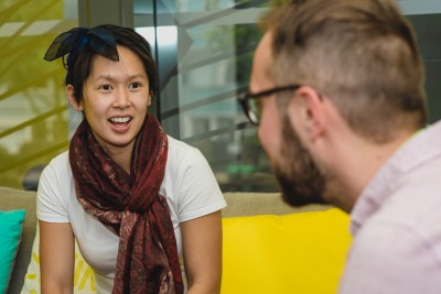 Person in scarf talking to glasses-wearing man